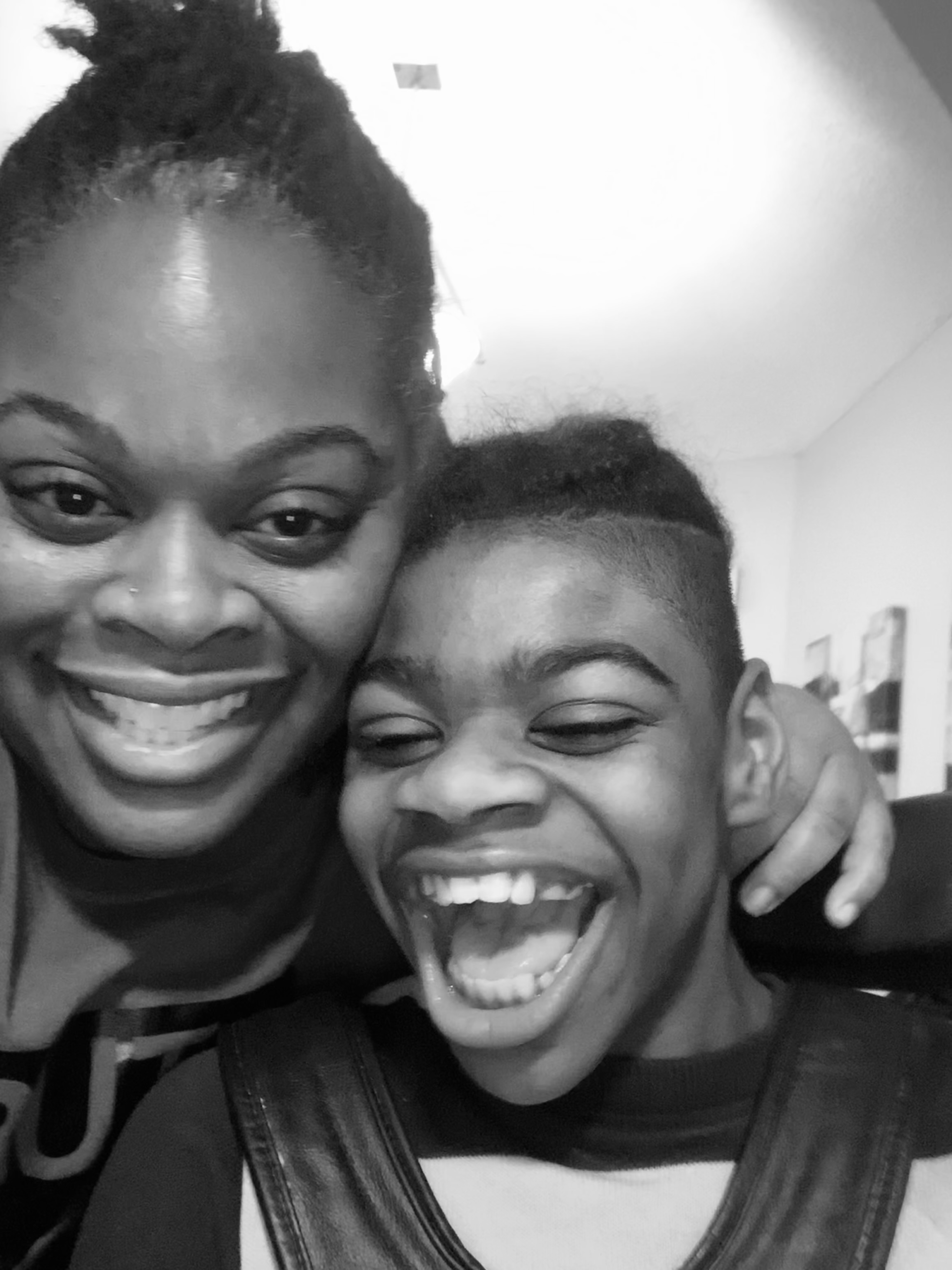 Mother laughing and smiling with her child during a playful moment at home